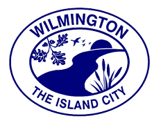 Wilmington, IL logo, text, design all blue,; a river running through an oval, with oak leaves in top of oval, cattails bottom right of oval